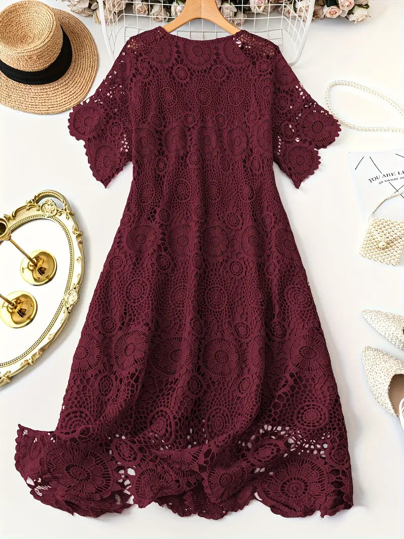 Burgundy lace dress on a white background with decorative items around