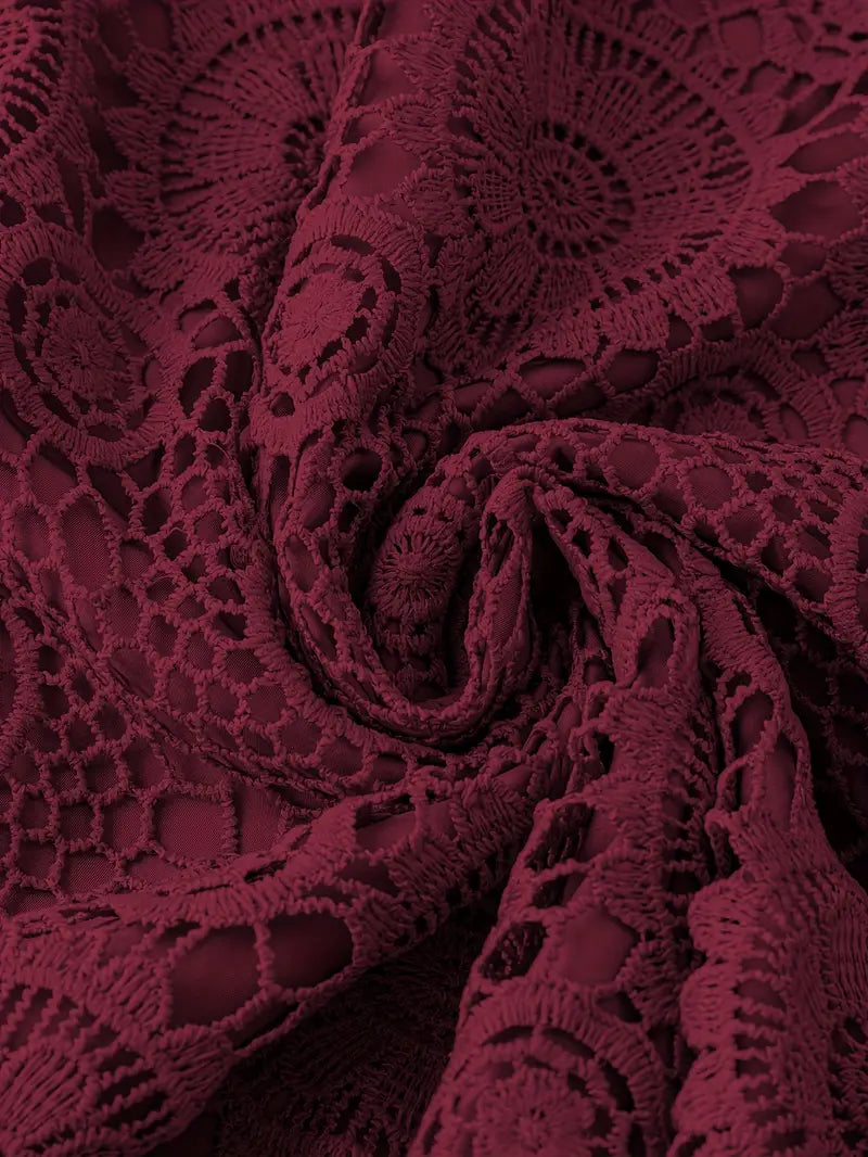 Close-up of burgundy lace fabric with intricate patterns