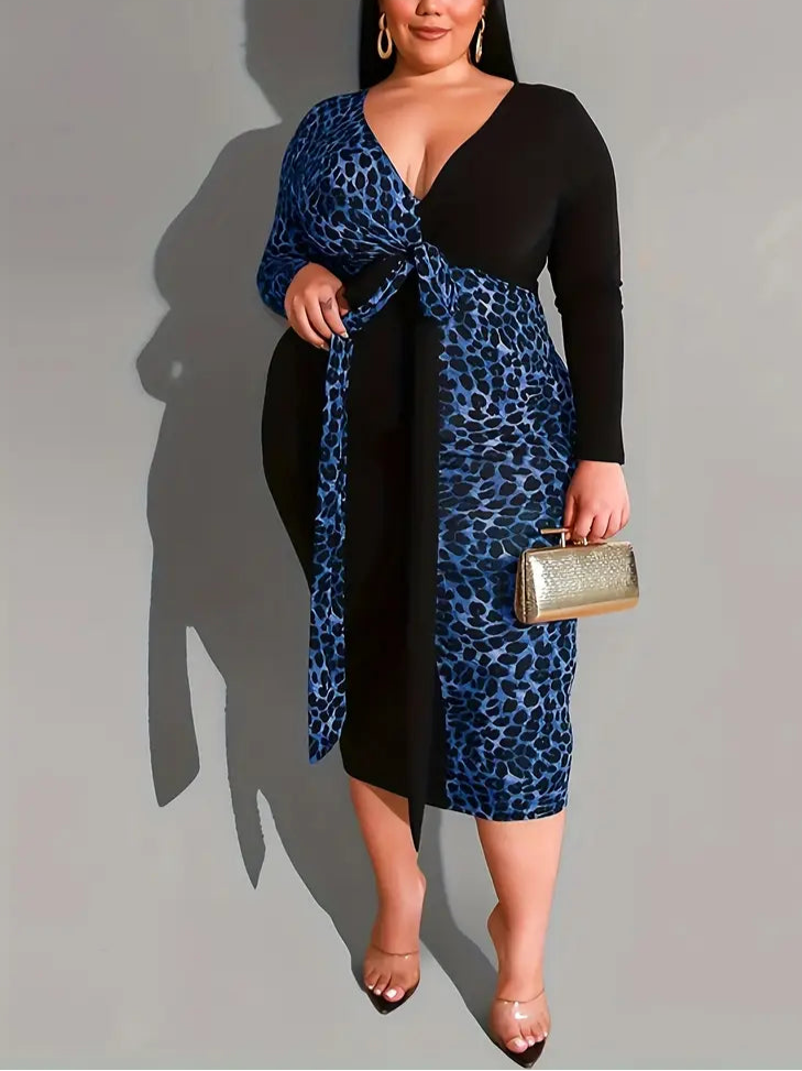 Woman wearing a black and blue leopard print dress holding a gold clutch against a gray background