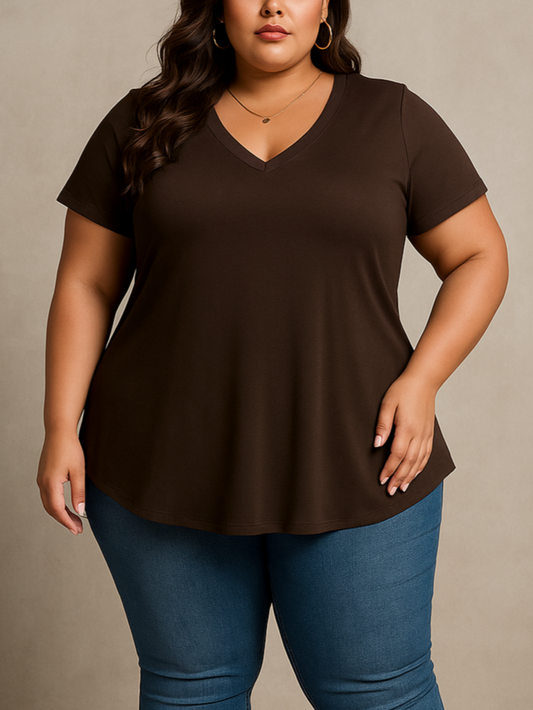 Plus size Woman wearing a brown top and blue jeans against a neutral background