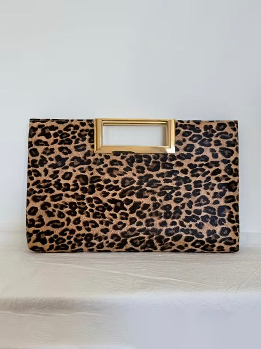 Leopard print handbag with a gold handle on a white background