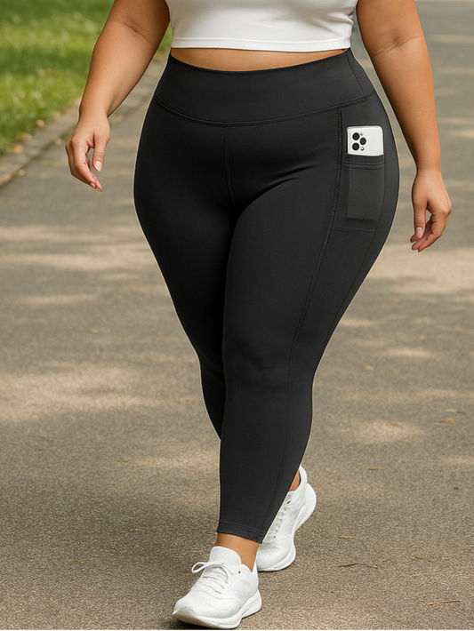Woman wearing a white sports bra and black leggings walking on a path in a park.