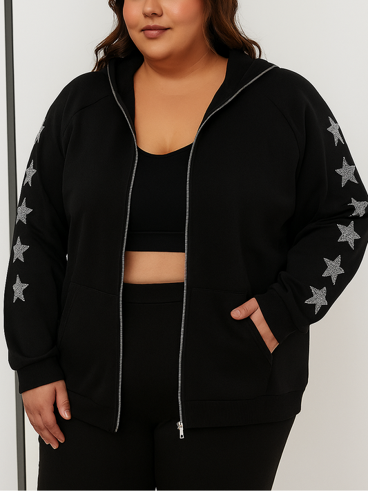 Person wearing a black zip-up hoodie with star patterns on the sleeves against a white background
