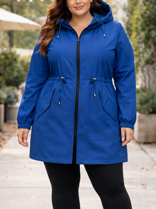 Woman wearing a blue raincoat outdoors on a sidewalk.