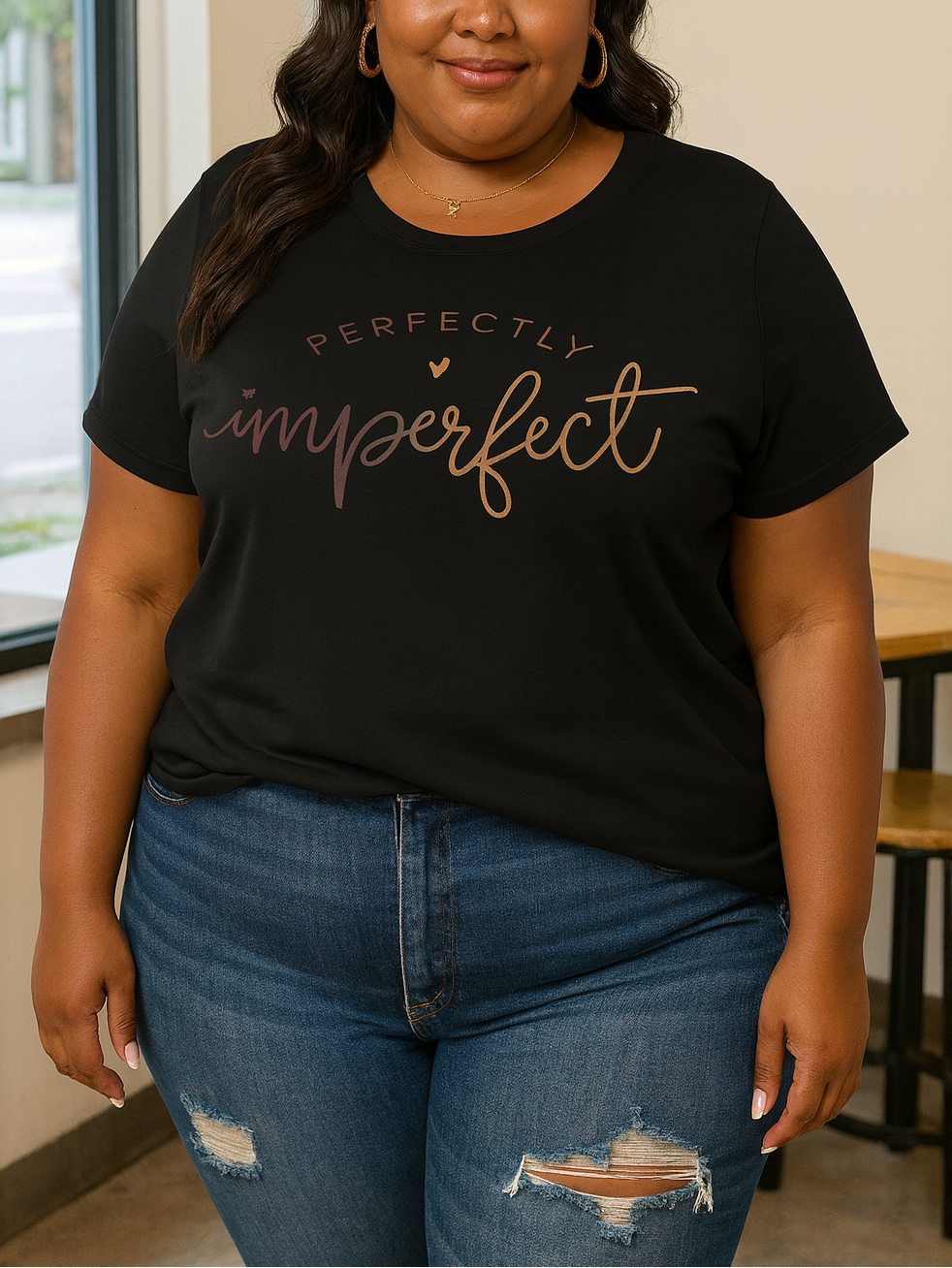 Woman wearing a black t-shirt with 'Perfectly Imperfect' text in a casual setting.
