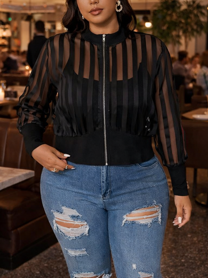 Woman in a restaurant wearing a black sheer top and ripped jeans.