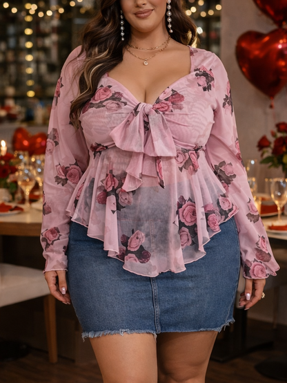 Woman in a floral blouse and denim skirt standing in a decorated room with heart balloons and candles.