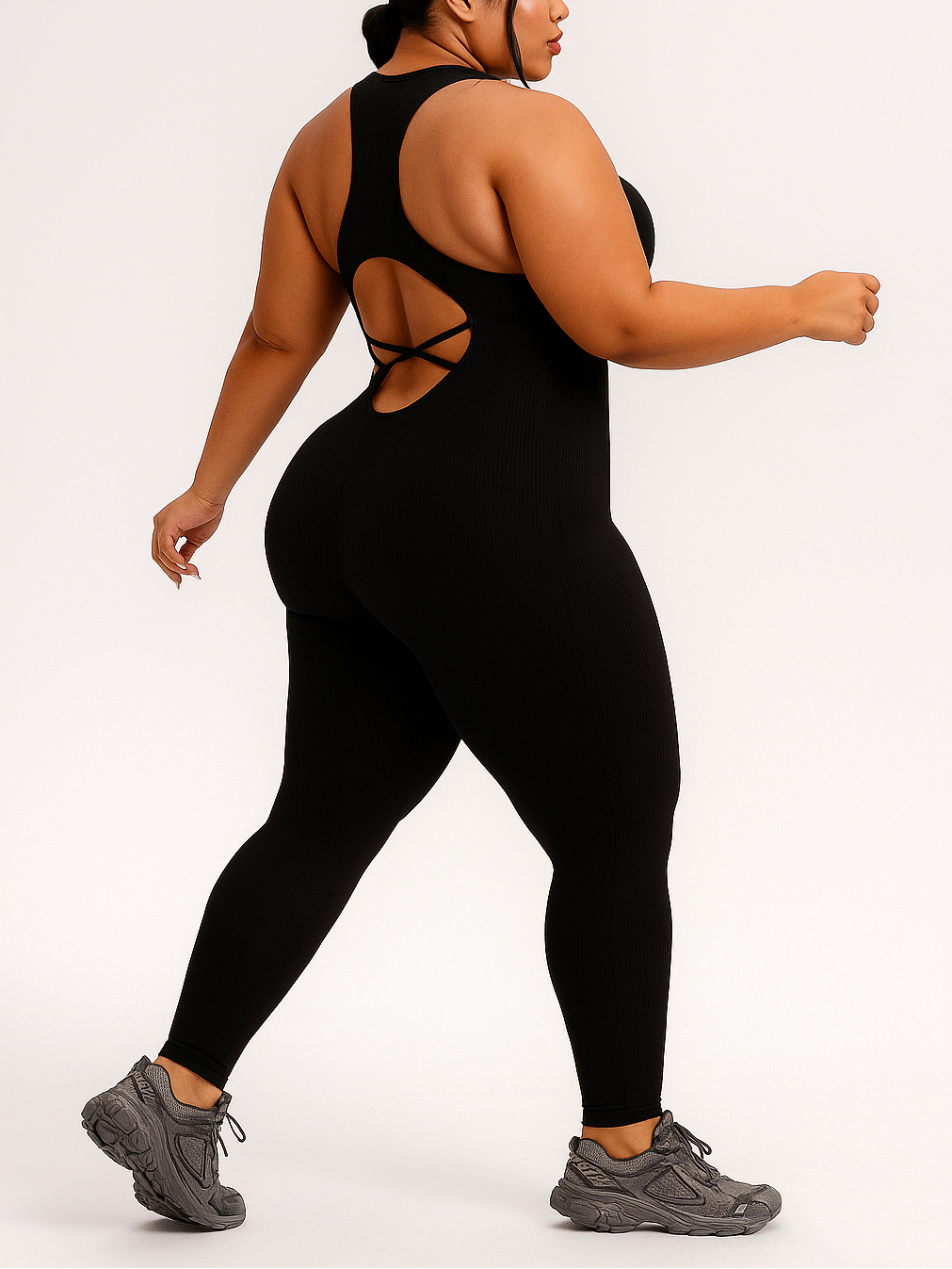 Person wearing a black jumpsuit with cut-out design on a white background