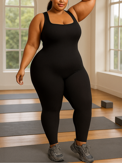 Person wearing a black bodysuit in a room with yoga mats and windows.