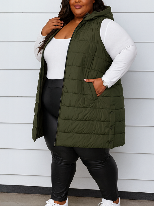 Person wearing an olive green puffer vest over a white long-sleeve shirt and black leggings against a light gray background.