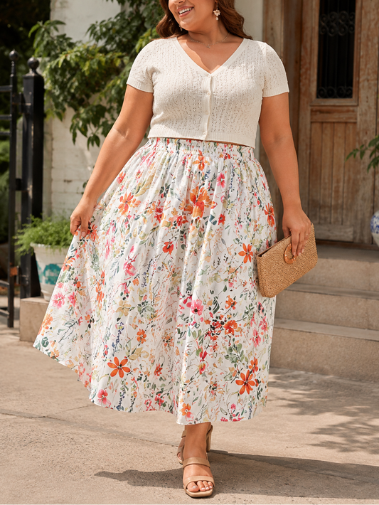 Woman wearing a floral dress and white top outdoors.