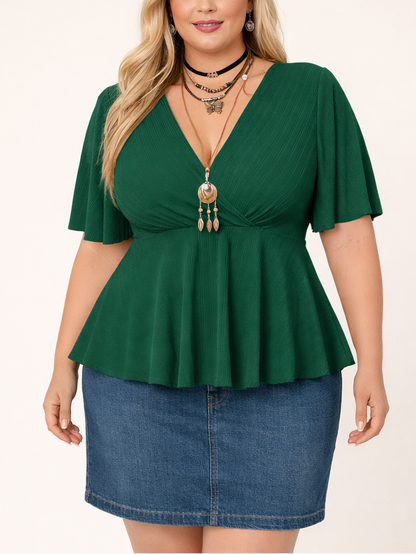 Woman wearing a green peplum top and denim skirt on a white background