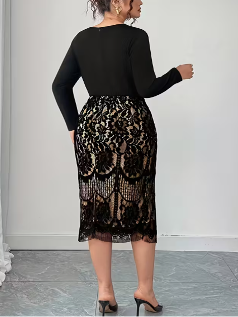 Woman wearing a black long-sleeve top and a black lace skirt against a white wall.