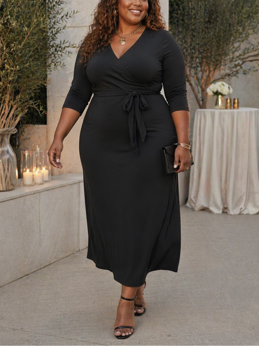 Woman wearing a black dress standing outdoors with decorative elements in the background