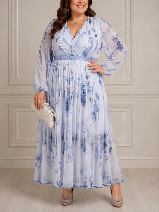 Woman wearing a blue floral dress against a beige wall.