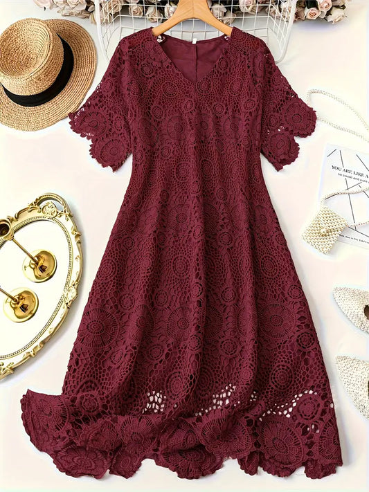 Maroon lace dress on a hanger with decorative items around