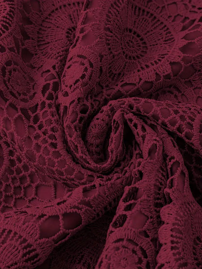 Close-up of burgundy lace fabric with intricate patterns