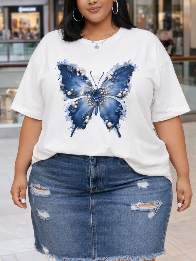 Woman wearing a white t-shirt with a blue butterfly design and a denim skirt in a mall.