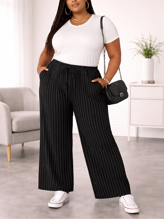 Woman wearing a white top and black pinstripe pants in a living room setting.