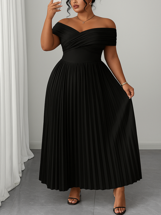 Woman wearing a black off-shoulder dress taking a mirror selfie.