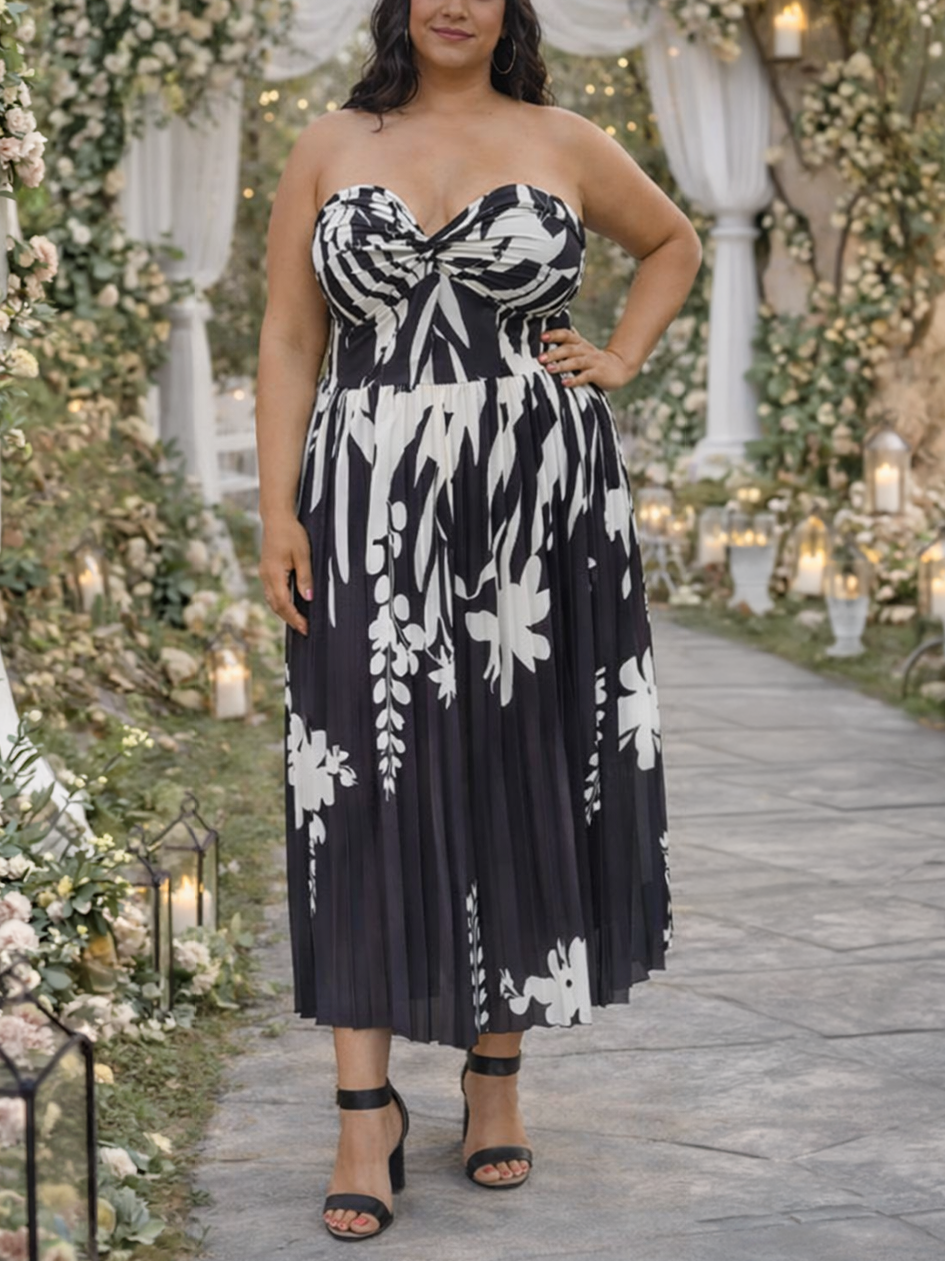 Woman in a black and white floral dress standing in a decorated outdoor setting with flowers and lights.
