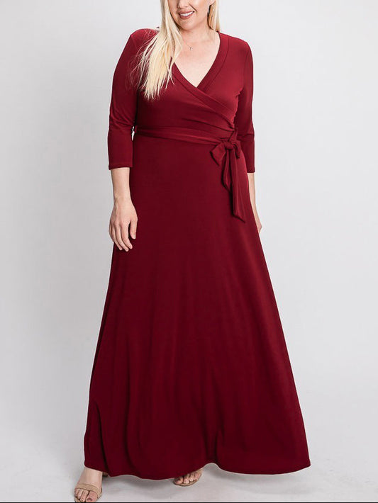 Woman wearing a burgundy wrap dress on a white background